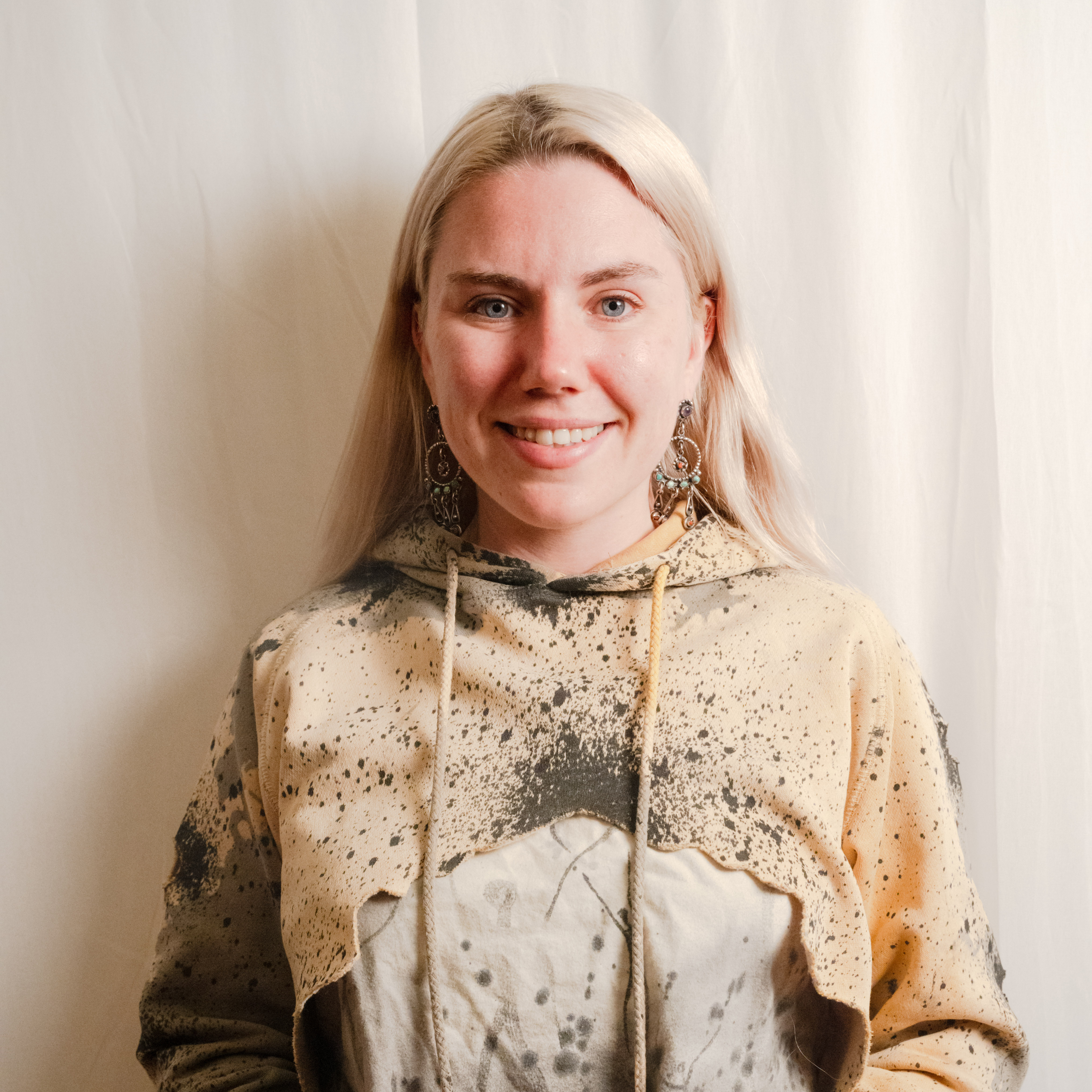 Photo of a blond woman with blue-green eyes and white background